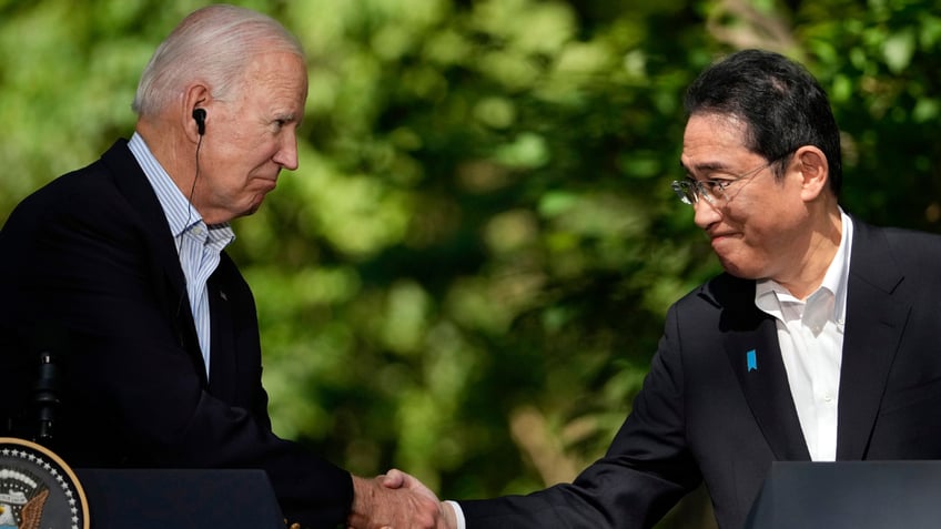 Joe Biden, left, shakes hands with Japan's Prime Minister Fumio Kishida