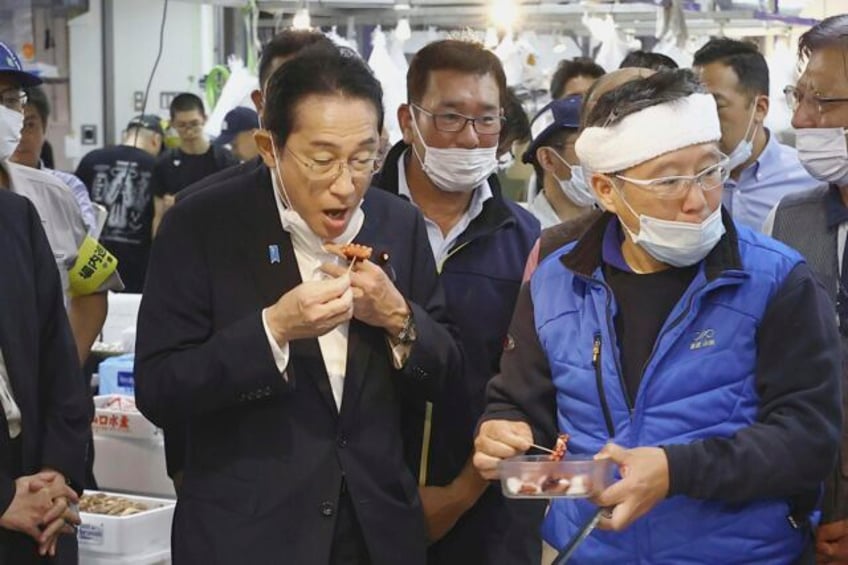 japans pm visits fish market vows to help fisheries hit by china ban over fukushima water release