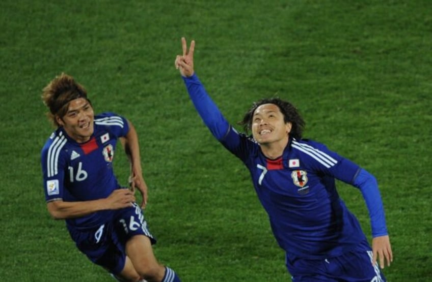 Yasuhito Endo (R) celebrates with Yasuhito Okubo after scoring as Japan beat Denmark at the 2010 World Cup