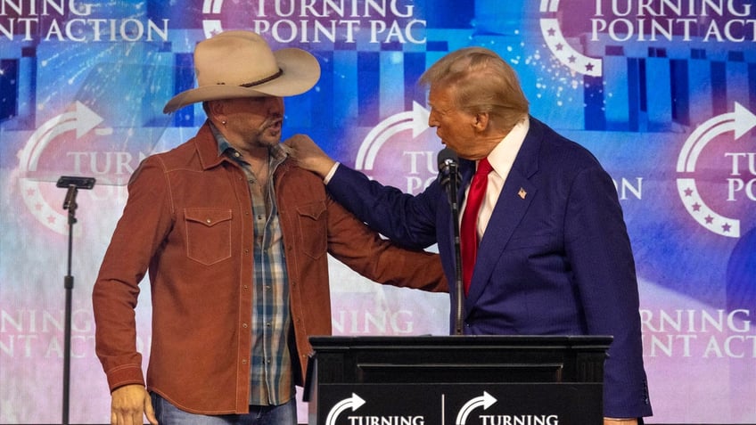 Jason Aldean speaks on stage with Donald Trump