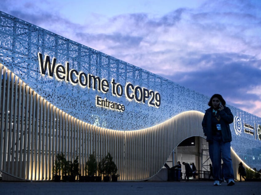 Pedestrians walk in front of the venue for COP 29 Summit in Baku on November 10, 2024, on