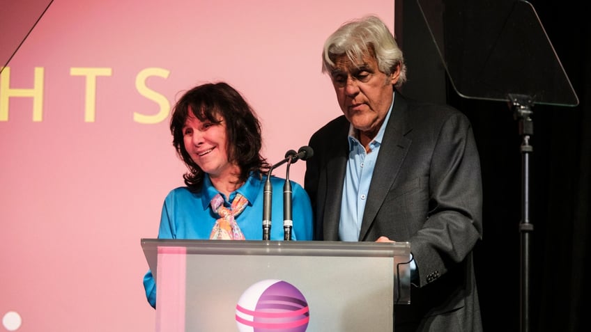 Jay Leno and Mavis on stage at a podium