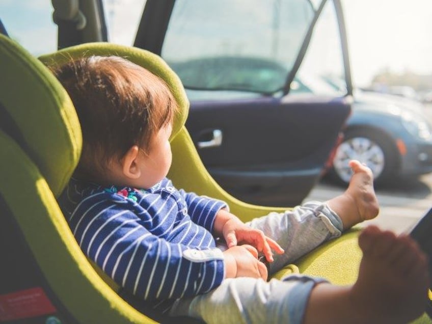 A baby sits in her car seat