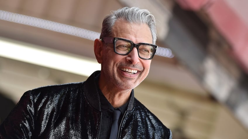 Jeff Goldblum wearing leather jacket and smiling