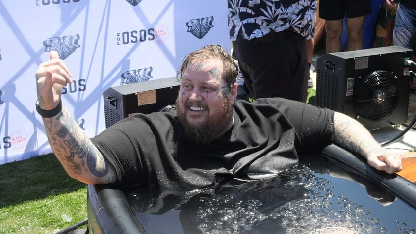 jelly roll smiling while sitting in a tub of water