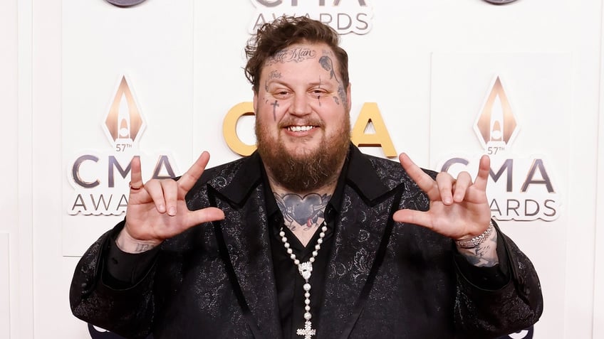 Jelly Roll puts up 'I love you' in sign language on the CMA Awards carpet
