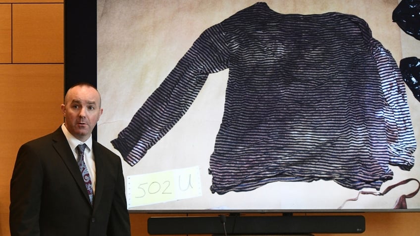 Connecticut State Police Sgt. Kevin Duggan shows a blood-like stain found on a women's long-sleeve shirt seized from a trash can on Albany Avenue in Hartford on day eight of Michelle Troconis' criminal trial at Connecticut Superior Court in Stamford, Conn. Tuesday, Jan. 23, 2024.