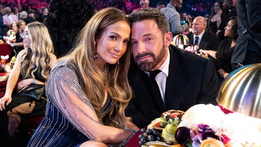 Jennifer Garner in a sequined dress soft smiles with husband Ben Affleck in a classic tuxedo, also soft smiling at the Grammys