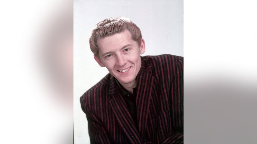 Jerry Lee Lewis wearing an oversized blazer and smiling