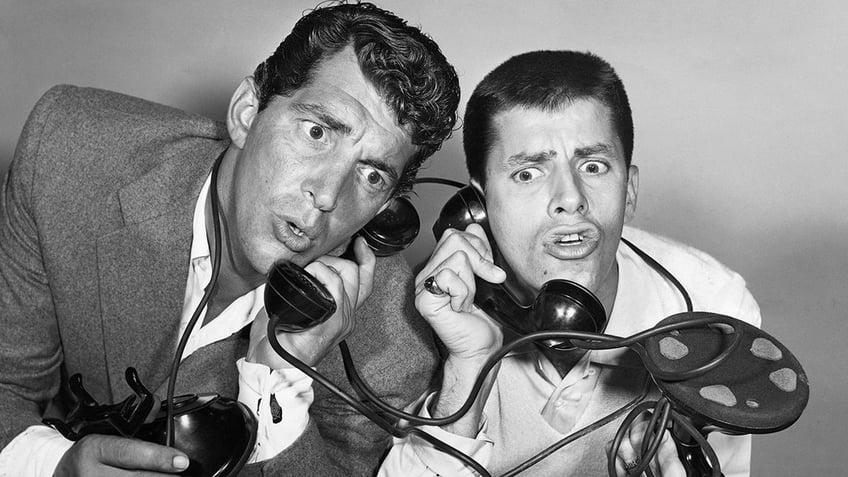 Dean Martin and Jerry Lewis looking surprised as they both hold phones.