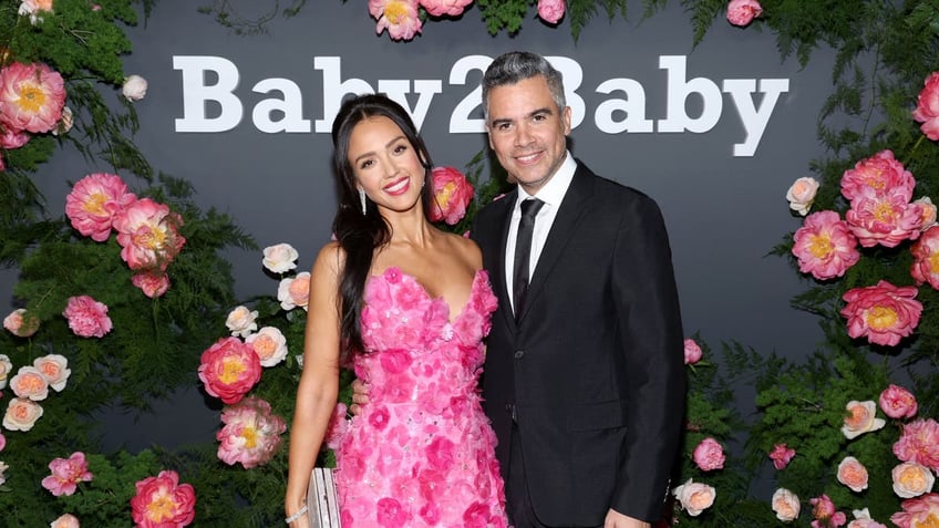 Jessica Alba in a pink dress posing with Cash Warren