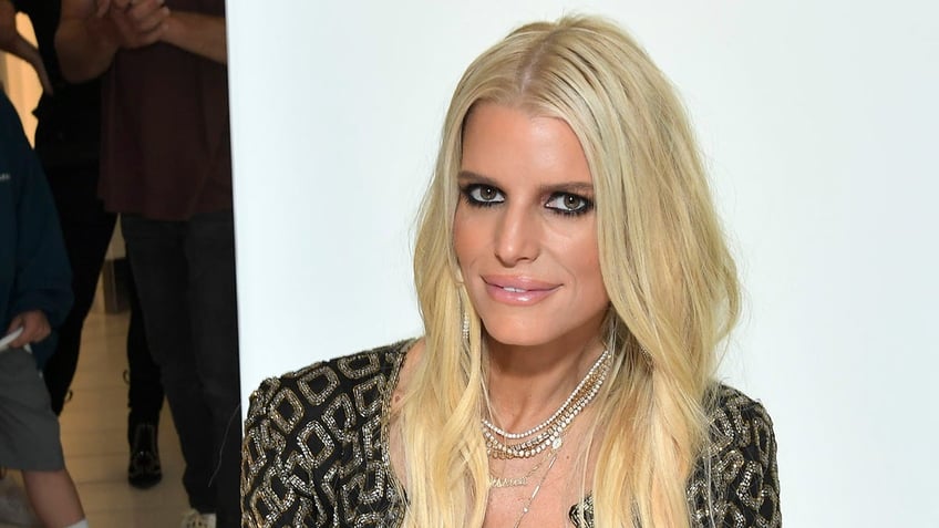 Jessica Simpson soft smiles and looks slightly up at an event at The Grove