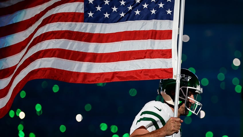 jets aaron rodgers carries american flag onto field in electric moment before injury