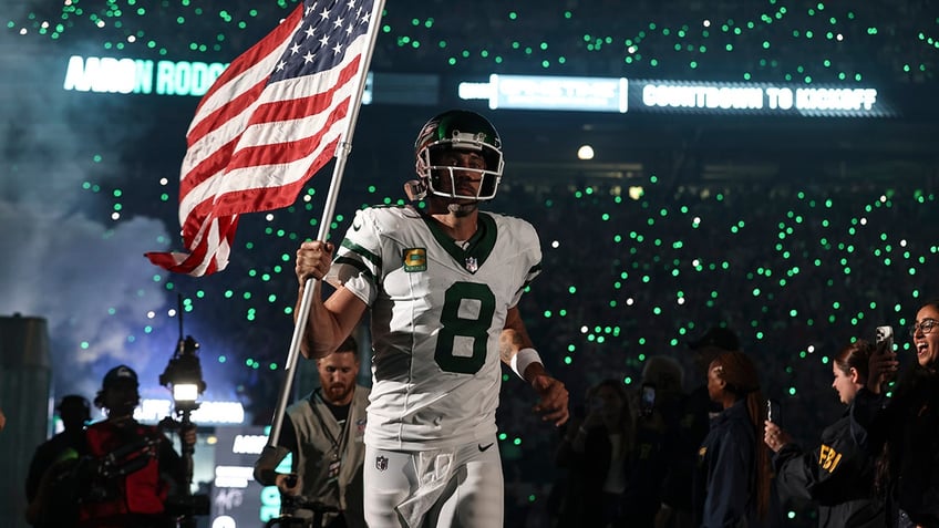 jets aaron rodgers carries american flag onto field in electric moment before injury