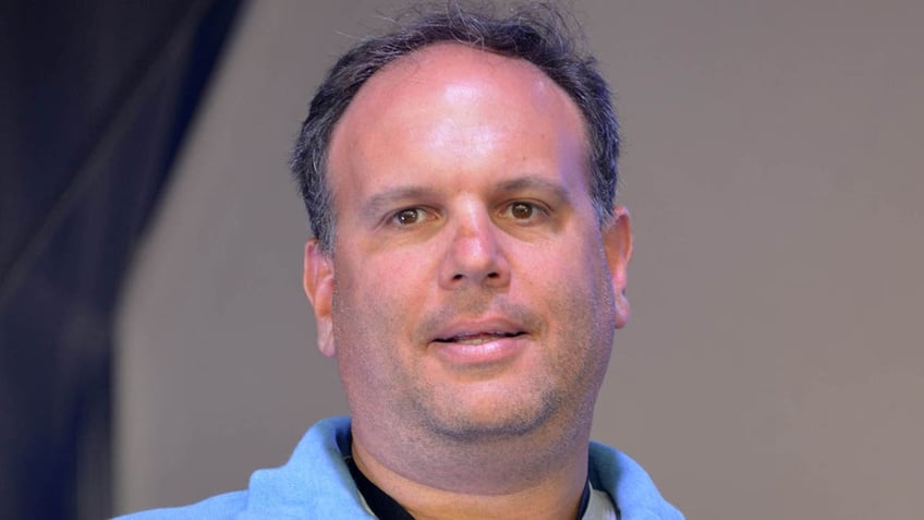 Mike Tannenbaum looks on