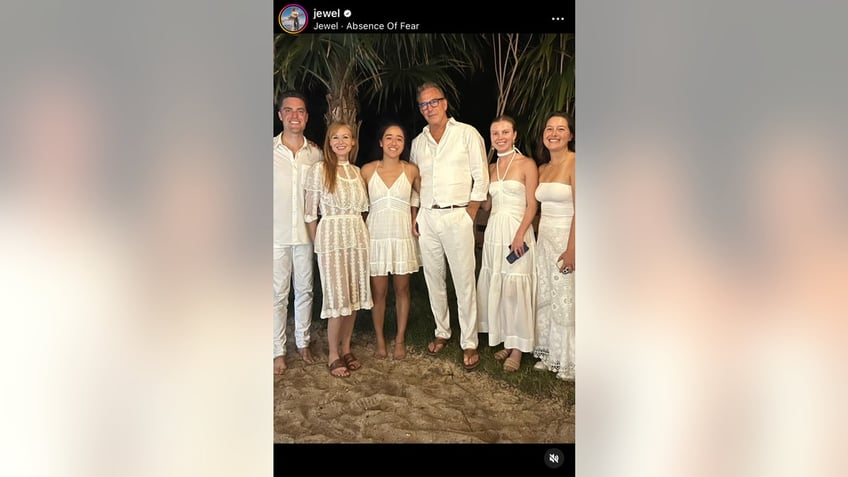 Group photo of Jewel and Kevin Costner with others all wearing white