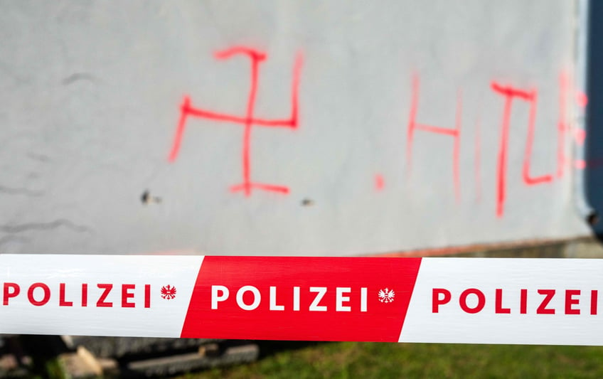 jewish cemetery set on fire and defaced with swastika and hitler graffiti in austria