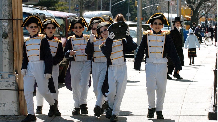 Kids walk on 14th Avenue dressed in costume.