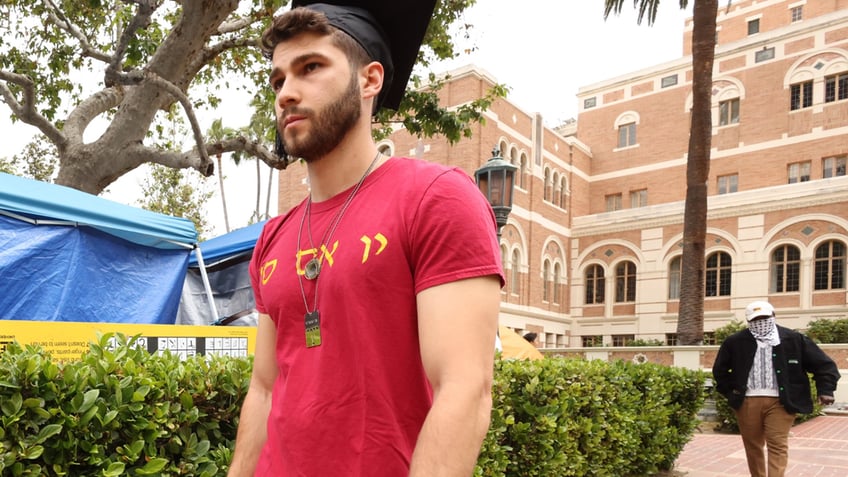 Mark Rayant in red shirt on campus