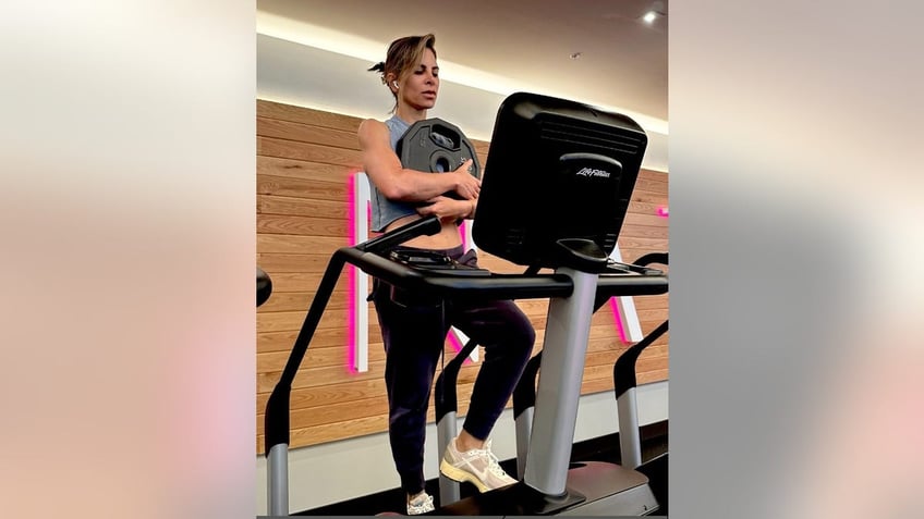 jillian michaels holding a weight on a stairstepper