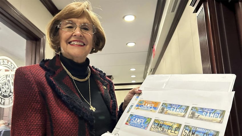 Florida Republican state Sen. Gayle Harrell shows samples of a proposed specialty license plate to honor singer Jimmy Buffett