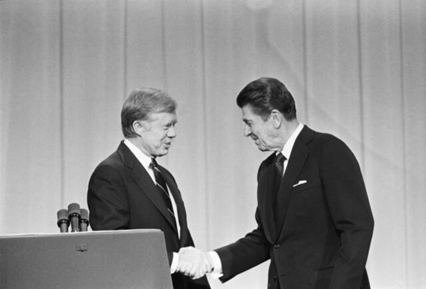 President Jimmy Carter and his Republican challenger, Ronald Reagan, shake hands as they g