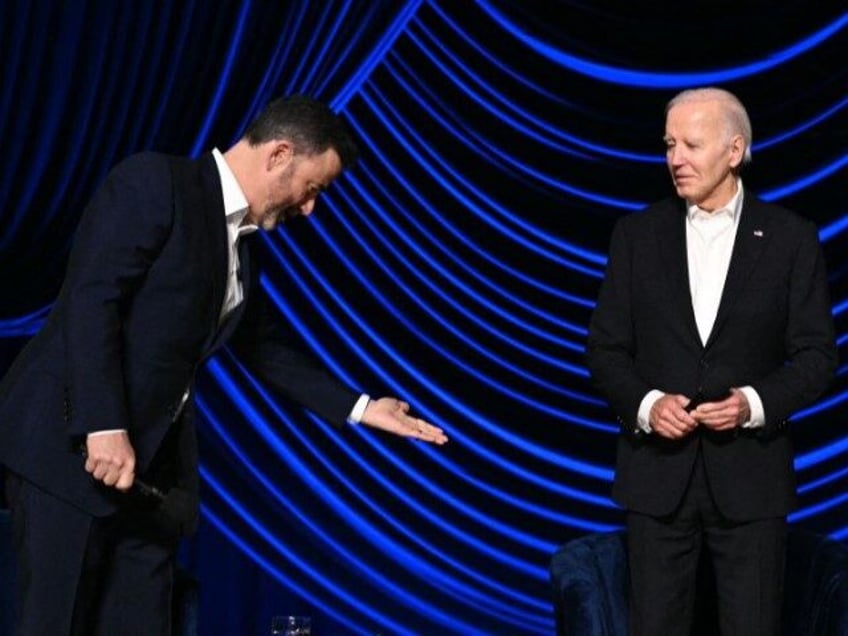 US television host Jimmy Kimmel (L) gestures to offer US President Joe Biden a seat onstag