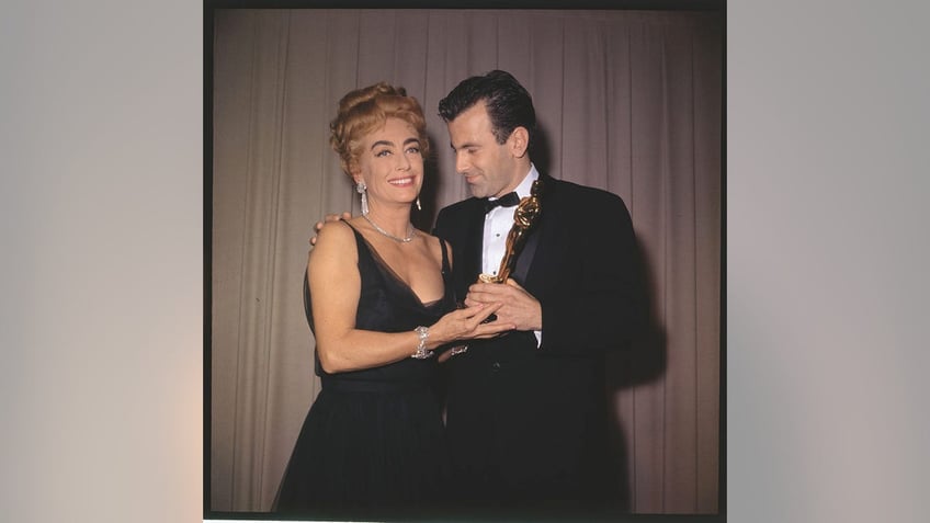 Joan Crawford holding an Oscar with a male star