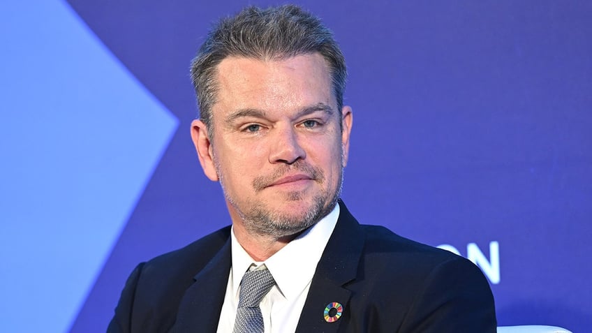 Matt Damon on stage in a dark suit looks dapper