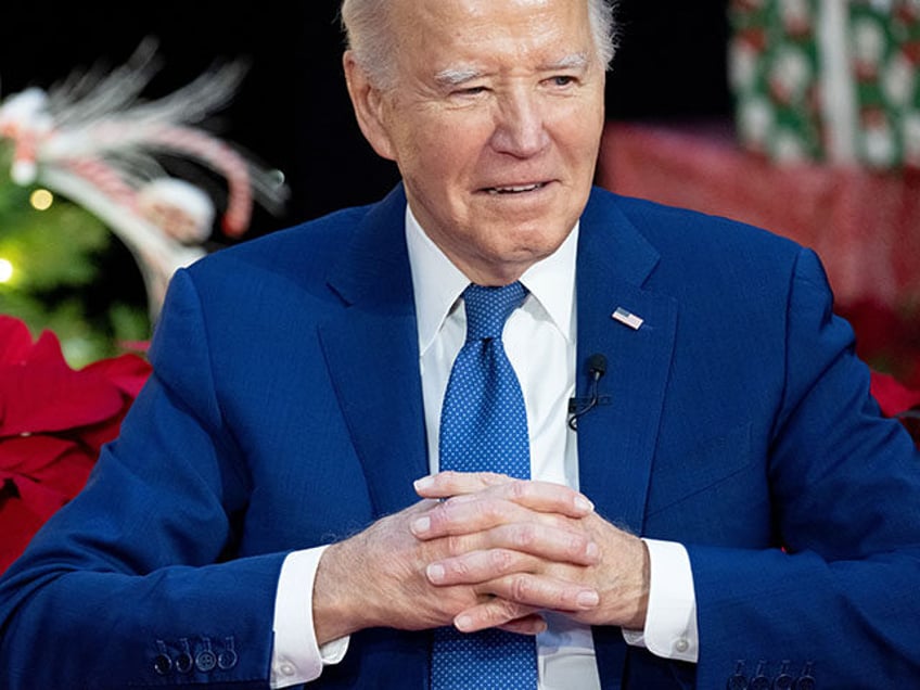 President Joe Biden looks on as First Lady Jill Biden as reads "'Twas The Night Before Christmas" during a holiday visit to patients and families at Children's National Hospital in Washington, DC, on December 22, 2023. (Photo by SAUL LOEB / AFP) (Photo by SAUL LOEB/AFP via Getty Images)