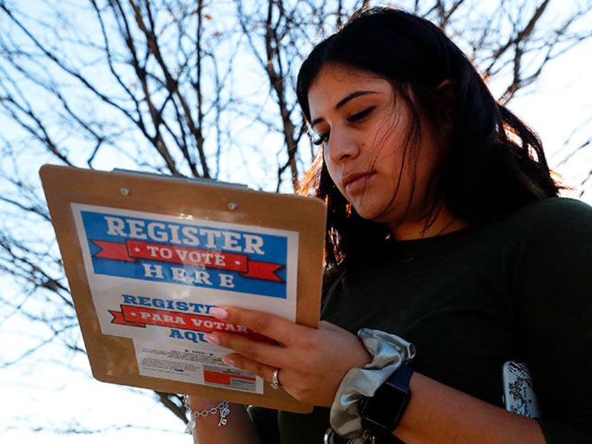 Karina Shumate, 21, a college student studying stenography, fills out a voter registration