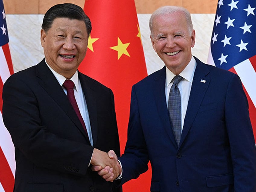 US President Joe Biden (R) and China's President Xi Jinping (L) shake hands as they m