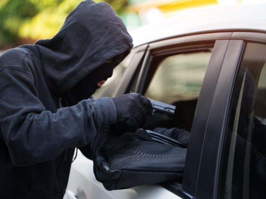 Car theft - thief trying to break into the vehicle.