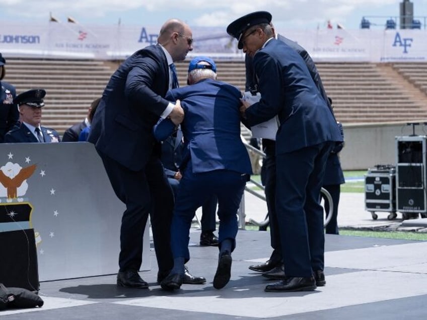 US President Joe Biden is helped up after falling during the graduation ceremony at the United States Air Force Academy, just north of Colorado Springs in El Paso County, Colorado, on June 1, 2023. (Photo by Brendan Smialowski / AFP) (Photo by BRENDAN SMIALOWSKI/AFP via Getty Images)