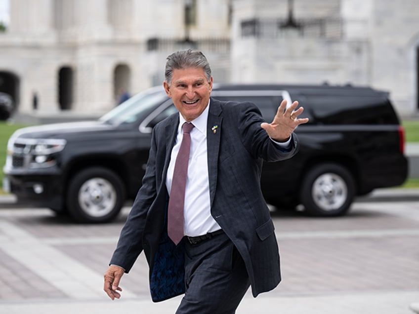 Sen. Joe Manchin, D-W. Va., waves to visitors on the Senate steps as he leaves the Capitol