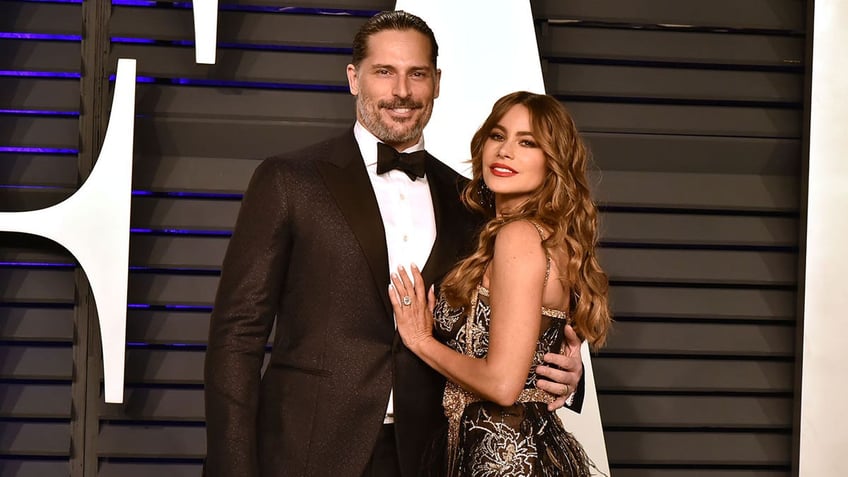 Soifa Vergara puts one arm on Joe Manganiello's chest in a black tuxedo