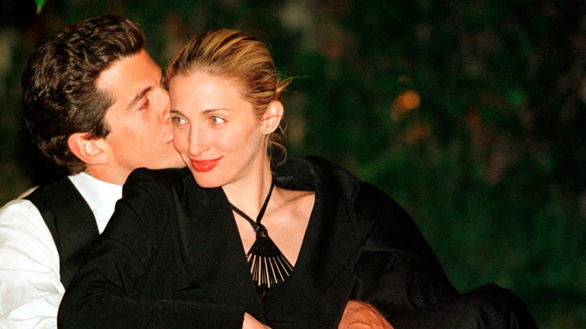 John F. Kennedy Jr. kissing Carolyn Bessette-Kennedy on the cheek.