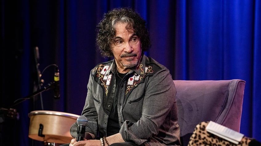 John Oates sitting on stage