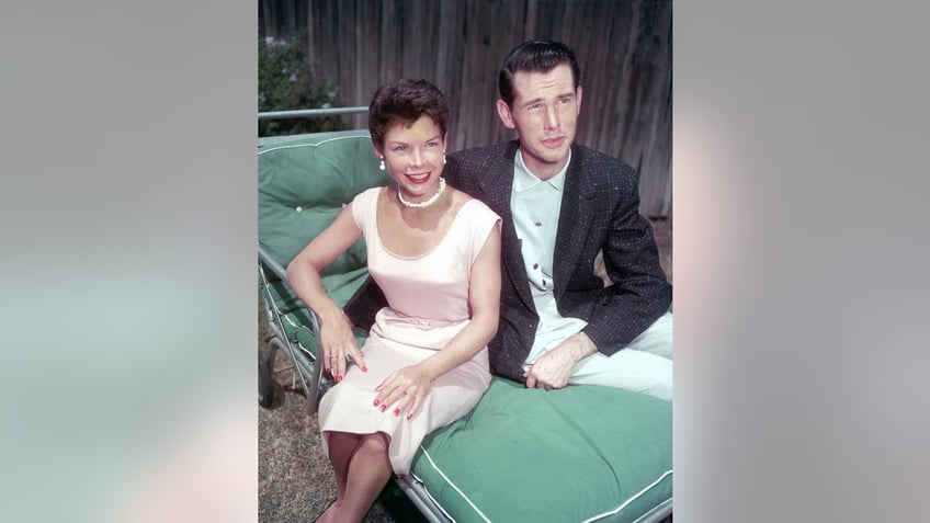 A young Johnny Carson sitting down with his wife Jody wearing a pale pink dress.