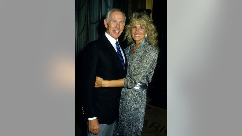 Johnny Carson being hugged by his fourth wife Alexis.