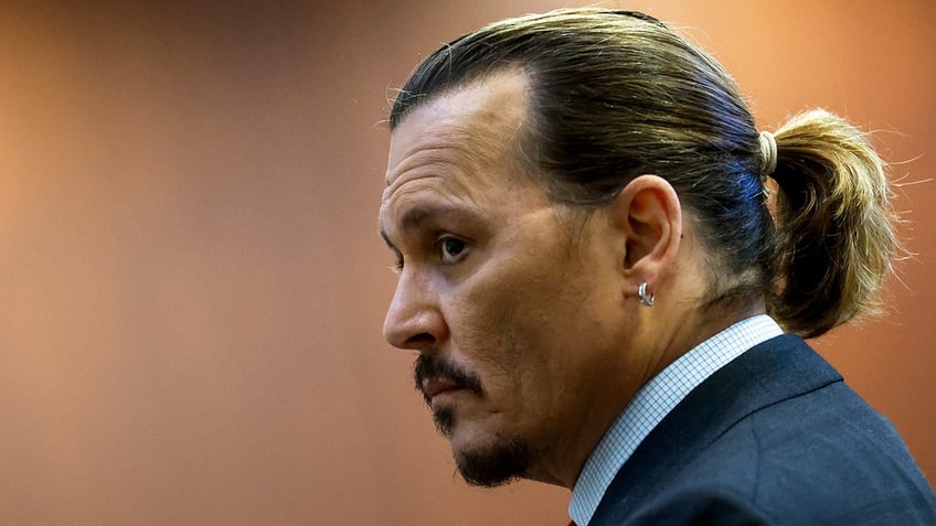 Johnny Depp looking concern as he faces to the side of the camera.
