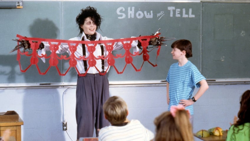 Edward scissorhands holds up artwork