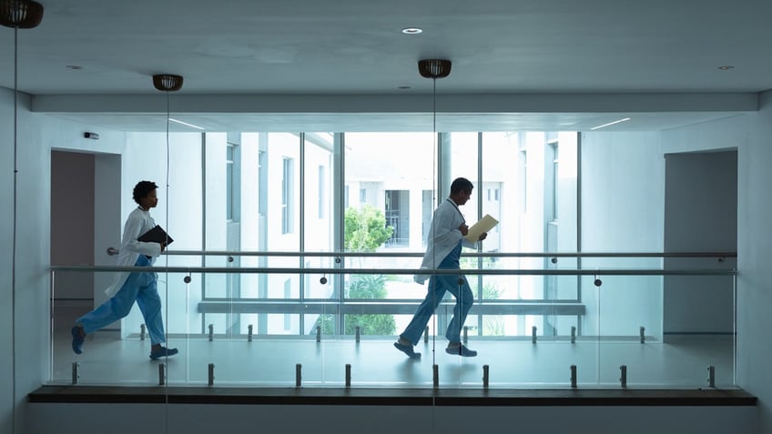 Male and female doctors running