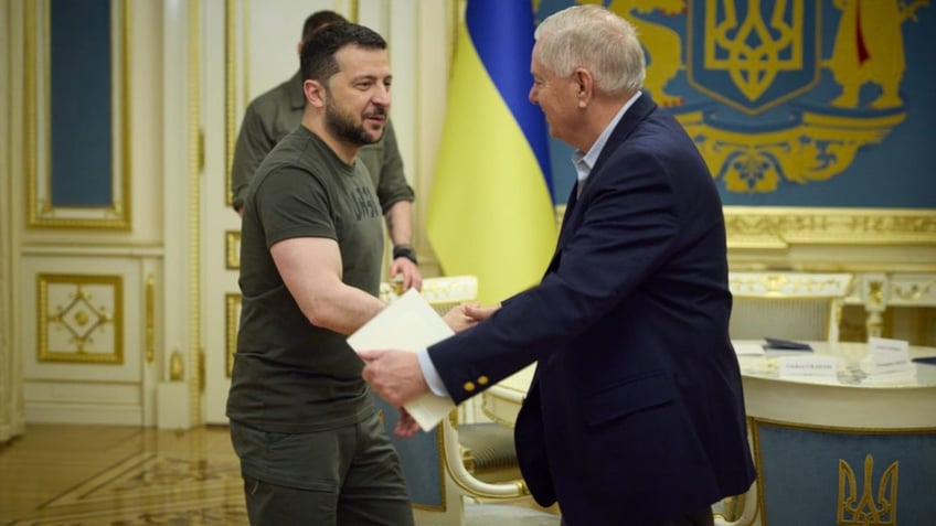 Ukrainian President Volodymyr Zelenskyy shakes hands with Sen. Lindsey Graham