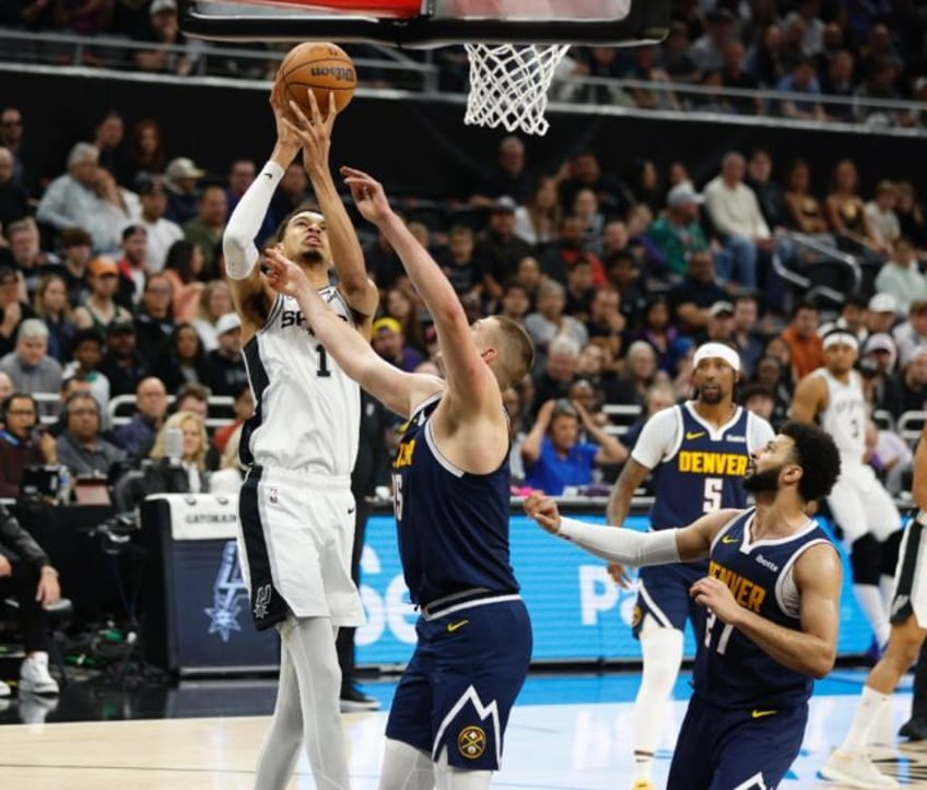 French rookie Victor Wembanyama, left, of the San Antonio Spurs shoots over Serbian center