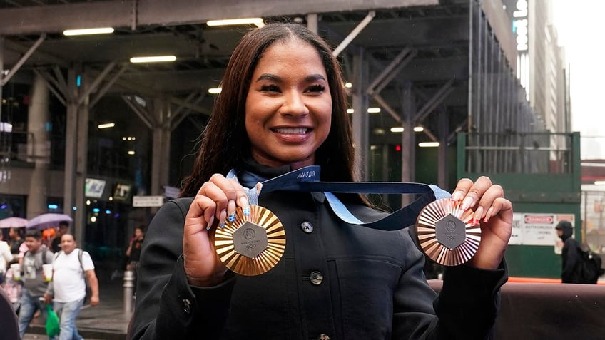 Jordan Chiles holds up her medals