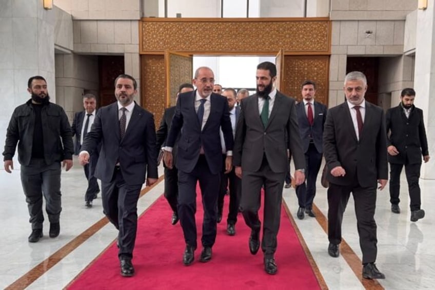 Jordanian Foreign Minister Ayman Safadi (C-L) is received by new Syrian leader Ahmed al-Sh