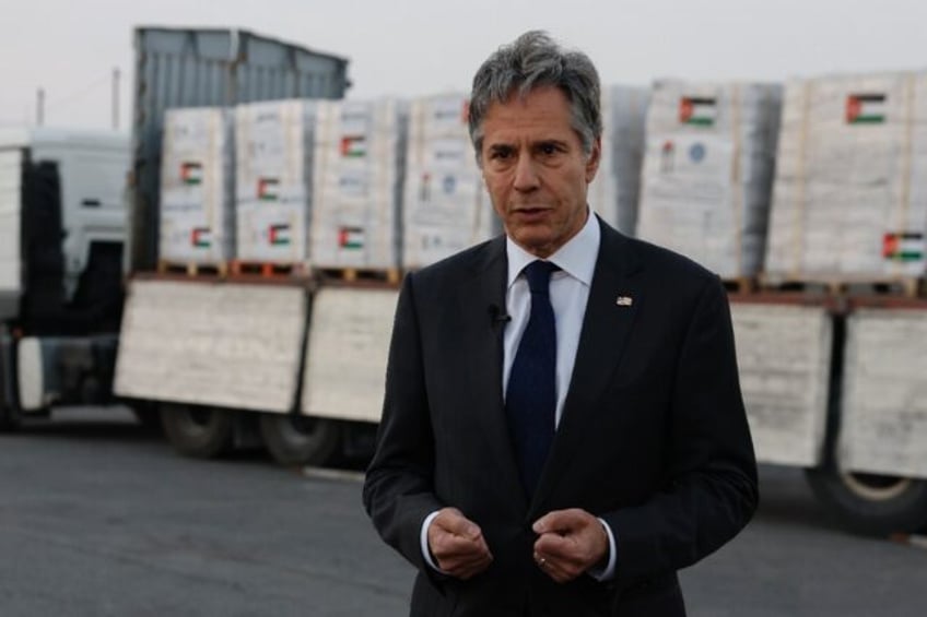 US Secretary of State Antony Blinken speaks to the press in front of a truck with humanita