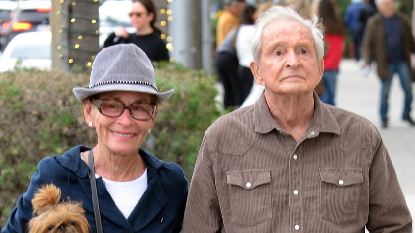 Judy Sheindlin and Jerry Sheindlin walking with their dog