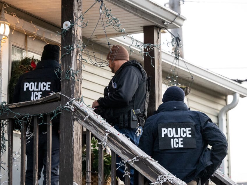 US Immigration and Customs Enforcement (ICE) agents knock on the door of a residence durin